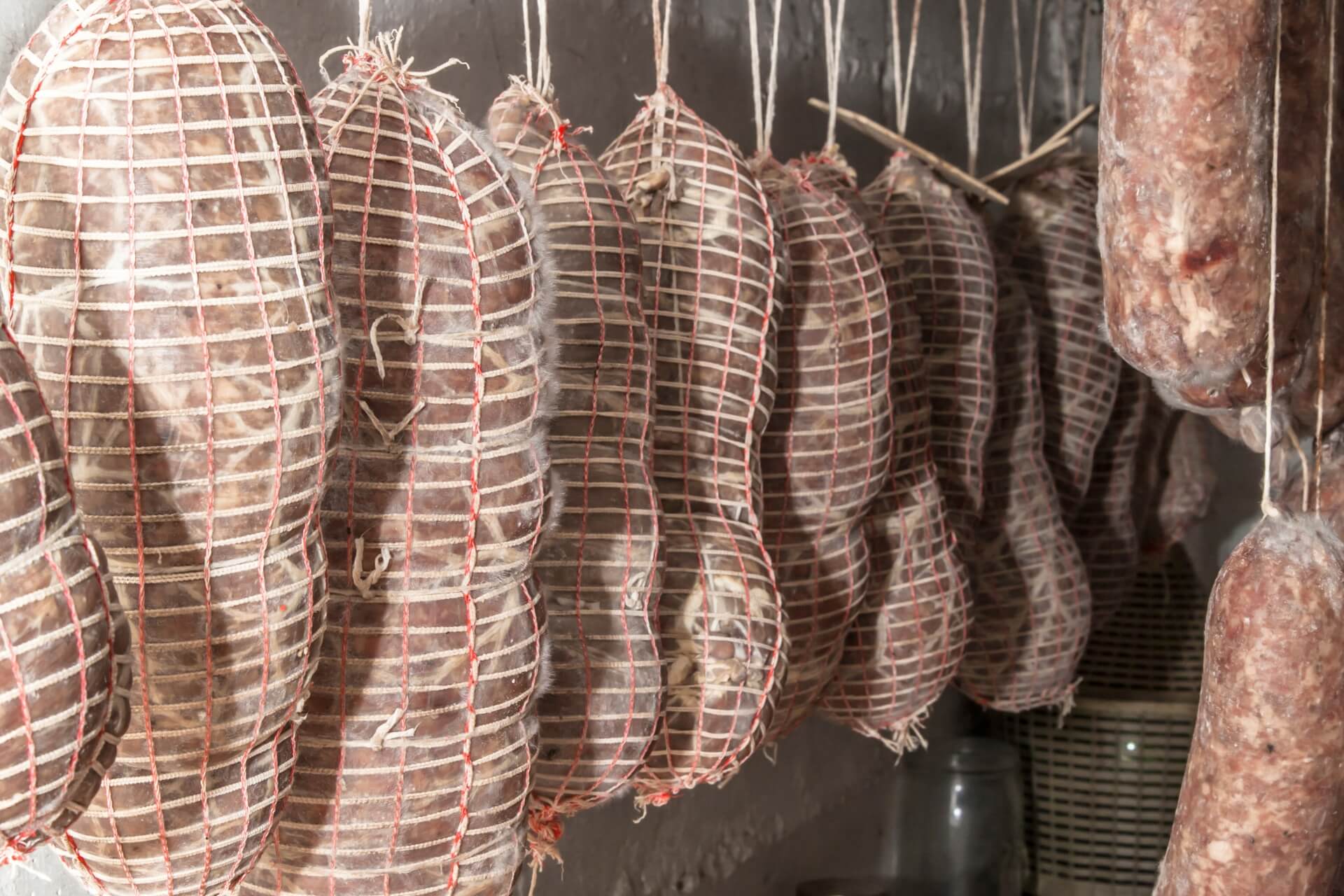 salumi appesi in cantina per la conservazione e stagionatura del salame